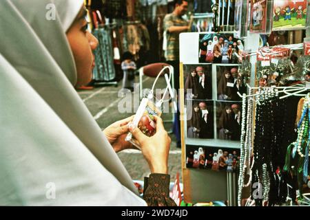 Una donna visitatrice viene fotografata da dietro, mentre si trova di fronte ai negozi di un centro commerciale di fronte alla moschea Daarut Tauhiid a Gegerkalong, Bandung, Giava Occidentale, Indonesia. Fondata dal famoso predicatore islamico indonesiano KH Abdullah Gymnastiar, Daarut Tauhiid e il suo ramo di gestione Manajemen Qolbu (mq) sono riusciti a intensificare il turismo religioso e le attività economiche nell'area di Gegerkalong nella città di Bandung. centinaia di migliaia di turisti spirituali venivano ogni giorno nell'area di Gegerkalong a Bandung, Giava Occidentale, Indonesia; per un tour religioso dentro e fuori... Foto Stock