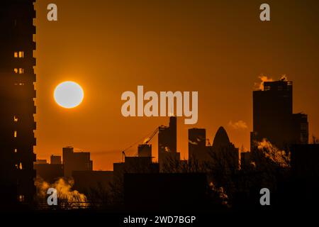 Londra, Regno Unito. 19 gennaio 2024. Il clima invernale fresco e gelido conduce a un cielo arancione mentre il sole sorge sulla City di Londra. Quando il vapore sale dalle unità di riscaldamento. Crediti: Guy Bell/Alamy Live News Foto Stock