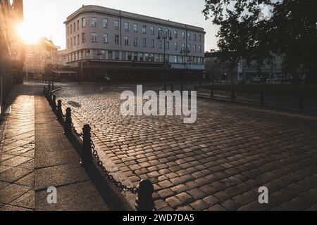 Un sentiero in mattoni contro gli edifici di Opole, Polonia, al tramonto dorato Foto Stock