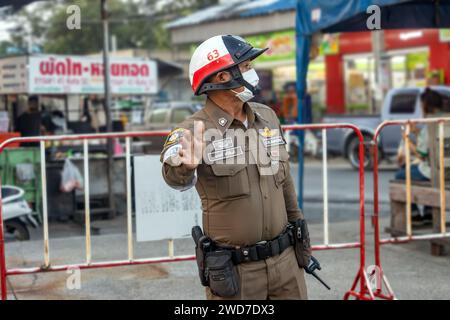 SAMUT PRAKAN, THAILANDIA, 11 novembre 2023, Un poliziotto dirige il traffico al crepuscolo sulla strada Foto Stock