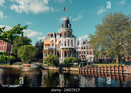 Una vista panoramica di splendidi edifici lungo un fiume ad Amsterdam, Paesi Bassi Foto Stock