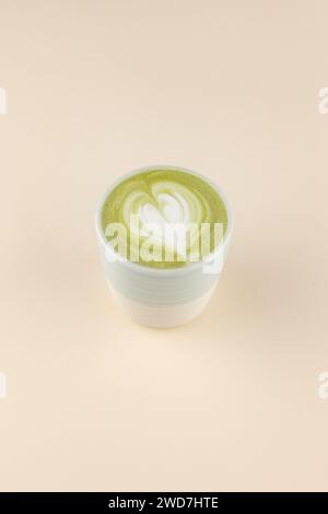 latte matcha su una tazza su sfondo rosa chiaro Foto Stock