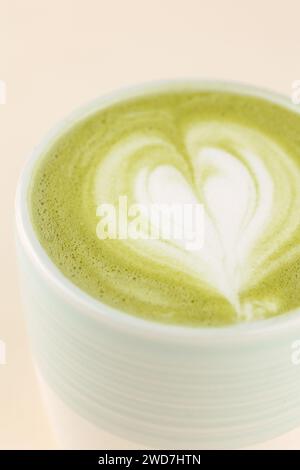 latte matcha su una tazza su sfondo rosa chiaro Foto Stock