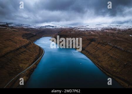 Vista aerea del fiordo e delle montagne ricoperte di neve, Isole Faroe Foto Stock