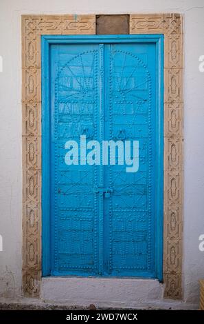 Un'antica porta blu decorata con simboli berberi nel cuore dell'antica medina a Kairouan, in Tunisia. Kairouan è la quarta città più Santa dell'Islam Foto Stock