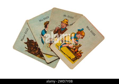 Vecchie famiglie felici e retrò giocano a carte isolate su sfondo bianco - la famiglia Giles, il contadino Giles con moglie, figlio e figlia - Regno Unito Foto Stock