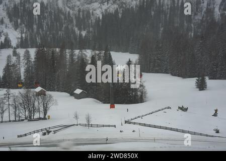 Strada di montagna in inverno sotto una funivia colorata Foto Stock