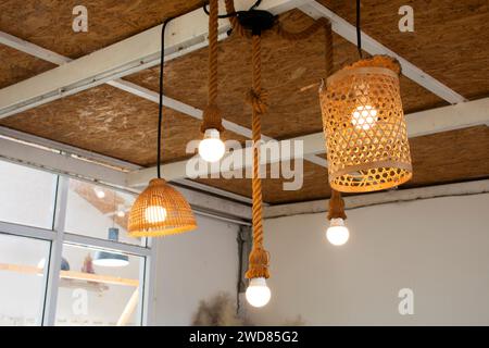 Arredamento interno e illuminazione lampada a sospensione a soffitto con tessitura in vimini di bambù sul tetto in camera del classico hotel retrò vintage resort per tra Foto Stock