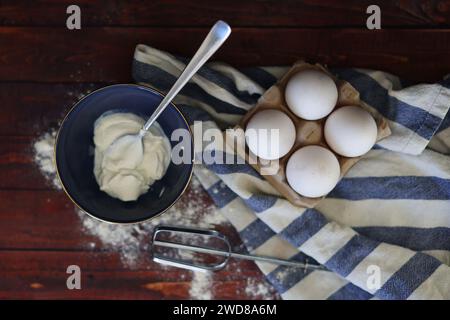 versare quattro uova in una frusta per mescolare la cottura Foto Stock
