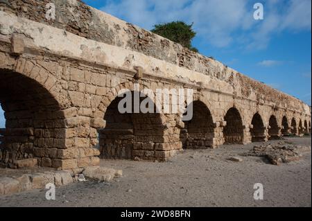 Archi in pietra e abutment dell'ampio acquedotto Adriano del Parco Nazionale di Caesarea Maritima lungo la costa mediterranea di Israele. Foto Stock