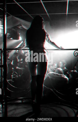 silhouette di una ballerina go-go sul palco di un nightclub. Foto in bianco e nero con effetto glitch e grana piccola Foto Stock