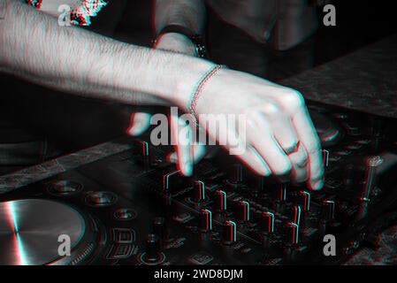 Ascolta musica da DJ su un mixer professionale in un nightclub a una festa ravvicinata. Foto in bianco e nero con effetto glitch e grana piccola Foto Stock