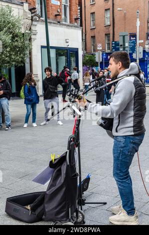 Dublino, Leinster, Irlanda settembre 26 2023 - Busker intrattiene gli acquirenti ascoltando la zona pedonale di Grafton Street nel centro di Dublino Foto Stock