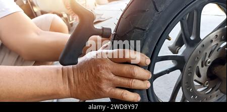 Tecnico che ripara gli pneumatici di una motocicletta Foto Stock