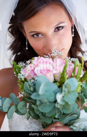 Sposa, bouquet e ritratto al matrimonio con fiori, orgoglio e impegno in occasione di eventi, celebrazioni e feste. Ragazza, matrimonio e piante floreali per Foto Stock