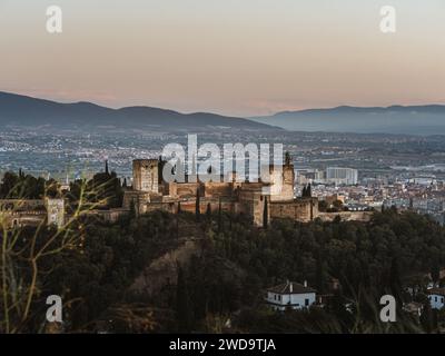 Vista panoramica del castello Alhambra di Granada, Andalusia, Spagna, durante il tramonto, dal Mirador de la Cruz de Rauda, ora dell'oro, cielo limpido, sole Foto Stock