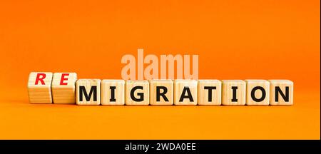 Simbolo di migrazione o di remigrazione. Concetto di Migration Remigration su bellissimi cubi di legno. Bellissimo sfondo arancione. Business migr Foto Stock