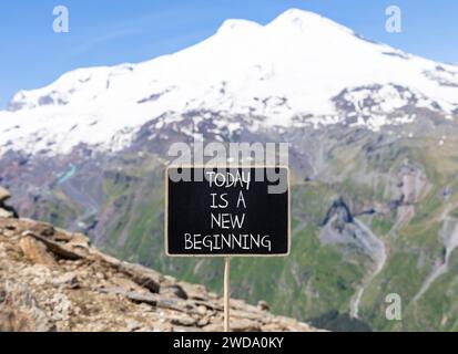 Oggi è un nuovo simbolo di inizio. Le parole concettuali di oggi sono un nuovo inizio sulla bella lavagna. Splendido sfondo montano dell'Elbrus. Business motiva Foto Stock