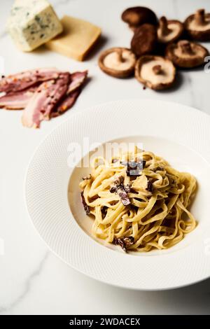 Alfredo Pasta con funghi shiitake e carciofi su fondo di marmo bianco. Foto di cibo minimalista. Foto Stock