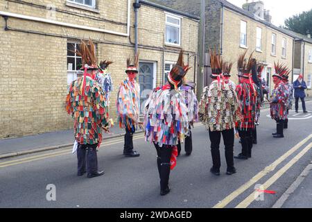 I membri del team Red Leicester Morris si esibiscono con facce dipinte di rosso in una strada laterale durante il festival Whittlesea Straw Bear Foto Stock