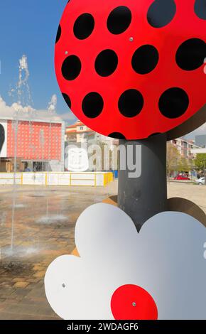 251 Piazza del Teatro a forma di triangolo - Sheshi i Teatrit - con fontane innaffiate e lampioni fortemente ornati. Korce-Albania. Foto Stock