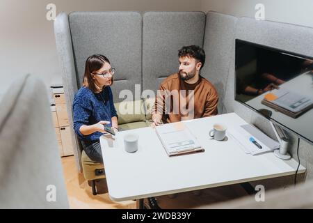 Due professionisti impegnati in una riunione d'affari in un ufficio moderno Foto Stock