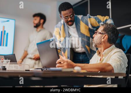 I professionisti discutono e collaborano in una sala conferenze, utilizzando la tecnologia per pianificare progetti di successo e aumentare i profitti. Foto Stock