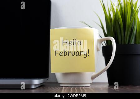 Ciao febbraio sulla nota adesiva sulla tazza da caffè Foto Stock