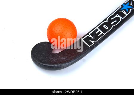 Dublino, Irlanda - 21 gennaio 2024: Una foto di un bastone da hockey Nedstar accanto a una pallina da hockey arancione su una superficie bianca. Foto Stock