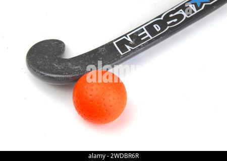 Dublino, Irlanda - 21 gennaio 2024: Una foto di un bastone da hockey Nedstar accanto a una pallina da hockey arancione su una superficie bianca. Foto Stock