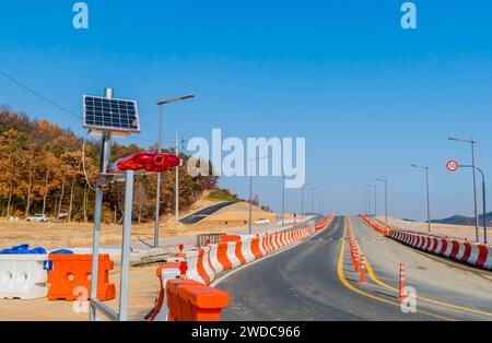 Luci lampeggianti rosse e blu montate su un telaio metallico alimentato da pannelli solari all'angolo stradale del nuovo cantiere, Corea del Sud, Corea del Sud Foto Stock