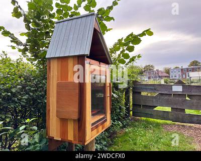 Scatola per libri in legno con cartello in lingua olandese all'aperto. Libreria gratuita Foto Stock