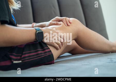 Mano di donna che tiene la coscia, dolore alle gambe spremere e massaggio per rilassarsi. Foto Stock