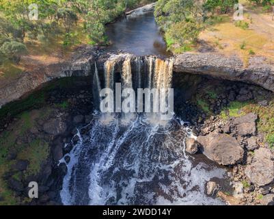 Vista aerea di una cascata che si tuffa su una sporgenza rocciosa in un grande cratere aperto a Wannon Falls nel Victoria occidentale, Australia. Foto Stock