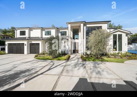 Casa bianca contemporanea con ben curati giardini di fronte al vialetto, nuova casa di costruzione a Tarzana, California Foto Stock