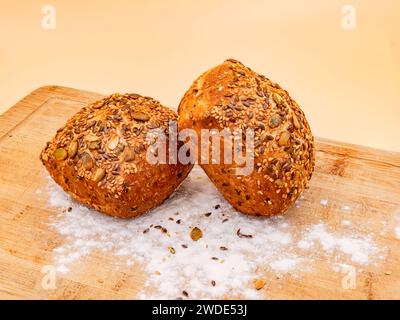 Shot Studio con panini di cereali interi disposti su un tavolo con farina fresca per colazione Foto Stock