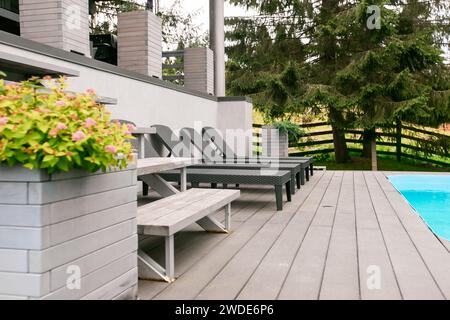 Ponte in legno, spiaggia, oceano, resort, lettini, ombrellone, piscina, cielo, alba Foto Stock