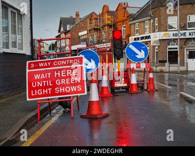 Wirral, Regno Unito - dicembre 31 2023: È in atto un sistema di controllo del traffico a tre vie durante i lavori stradali in un'area urbana del Regno Unito. L'immagine mostra i segni, i dissuasori e la con Foto Stock