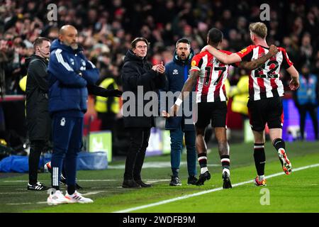 Ivan Toney di Brentford (secondo a destra) celebra il primo gol della loro squadra della partita con il manager Thomas Frank (centro) come il manager del Nottingham Forest Nuno Espirito Santo (secondo a sinistra) sembra frustrato durante la partita di Premier League al Gtech Community Stadium di Londra. Data immagine: Sabato 20 gennaio 2024. Foto Stock