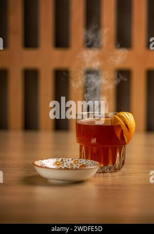 Tazza di tè caldo in vetro decorata con buccia d'arancia Foto Stock