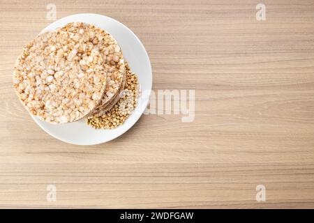 Pane croccante di grano saraceno su piatto su fondo di legno, senza glutine. Biscotti dietetici Foto Stock