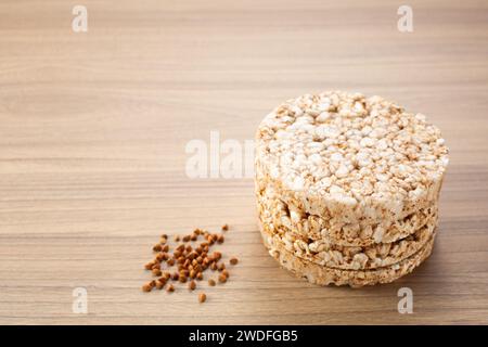 Croccante pane croccante di grano saraceno su fondo di legno con grano saraceno sparso intorno. Senza glutine. Biscotti dietetici. Foto Stock