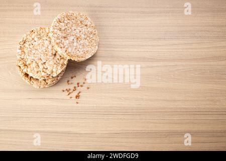 Croccante pane croccante di grano saraceno su fondo di legno con grano saraceno sparso intorno. Senza glutine. Biscotti dietetici. Foto Stock