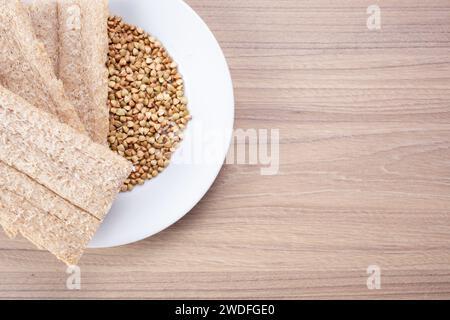 Pane croccante di grano saraceno e grano saraceno su piatto su fondo di legno, senza glutine. Biscotti dietetici Foto Stock