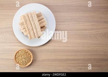 Pane croccante di grano saraceno e grano saraceno su piatto su fondo di legno, senza glutine. Biscotti dietetici Foto Stock