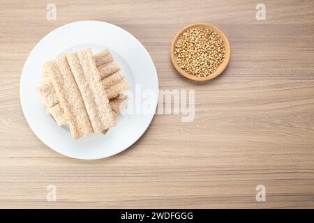 Pane croccante di grano saraceno e grano saraceno su piatto su fondo di legno, senza glutine. Biscotti dietetici Foto Stock