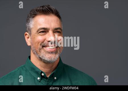 Felice uomo d'affari di mezza età che guarda da parte isolato su grigio. Primo piano. Foto Stock