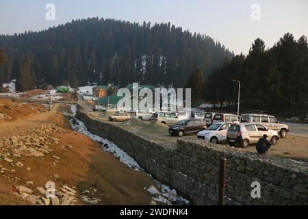 Srinagar Kashmir, India. 20 gennaio 2024. I veicoli parcheggiati sono visti a Gulmarg, a circa 55 km da Srinagar. Il prolungato periodo di secchezza di quest'inverno nella valle del Kashmir ha inferto un duro colpo alla famosa stazione sciistica di Gulmarg. Le piste da sci, un tempo trafficate, sono ormai senza neve e sono motivo di delusione per i turisti e in particolare per gli appassionati di sci. L'assenza di nevicate stagionali ha comportato la cancellazione delle prenotazioni di massa per i proprietari di hotel, con un grave impatto sulle loro attività. Questa battuta d’arresto imprevista sottolinea la vulnerabilità delle economie dipendenti dall’inverno e l’urgente necessità di strategie Foto Stock