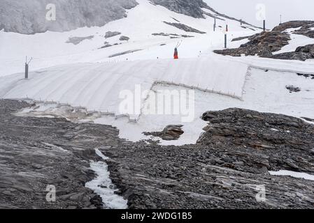 Un grande telone nevoso che protegge il ghiaccio del ghiacciaio Hintertux nelle Alpi, una pista da sci conduce in Austria Foto Stock