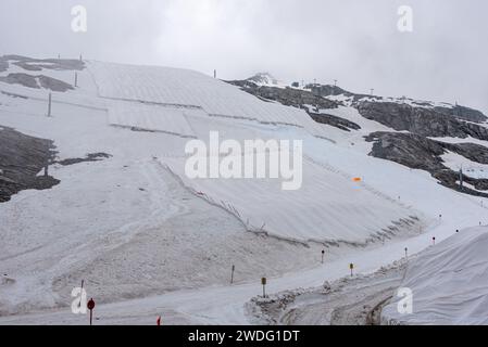 Un grande telone nevoso che protegge il ghiaccio del ghiacciaio Hintertux nelle Alpi, una pista da sci conduce in Austria Foto Stock